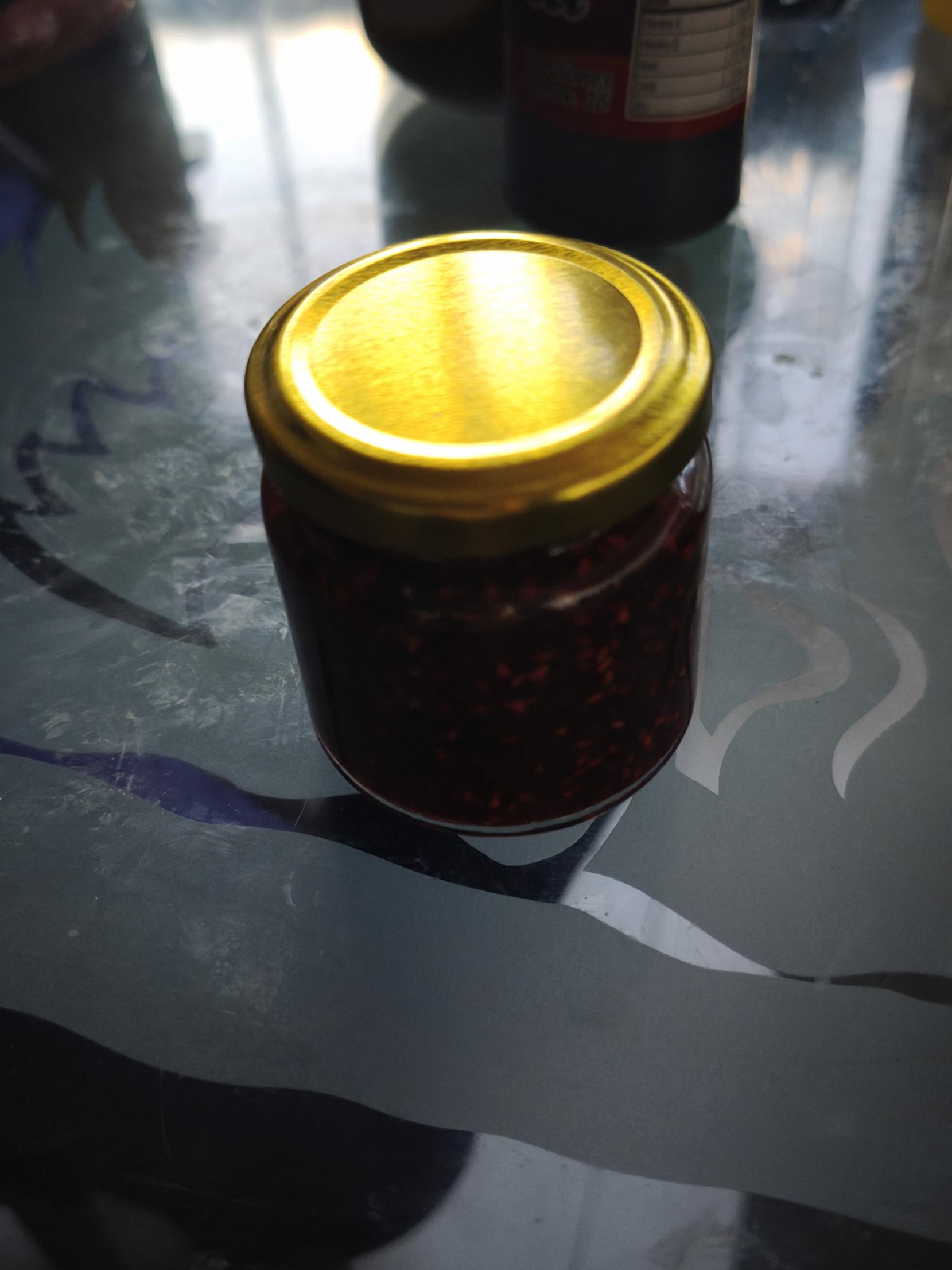 Frasco de mermelada de mora con tapa dorada
